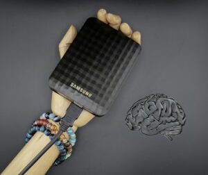 A hand holding a cell phone next to a brain